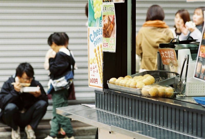 道端に座り込んで食べる人たち・・・を取るつもりだったけど、直前に車が通ったので、座りなおしたのは一人だけ