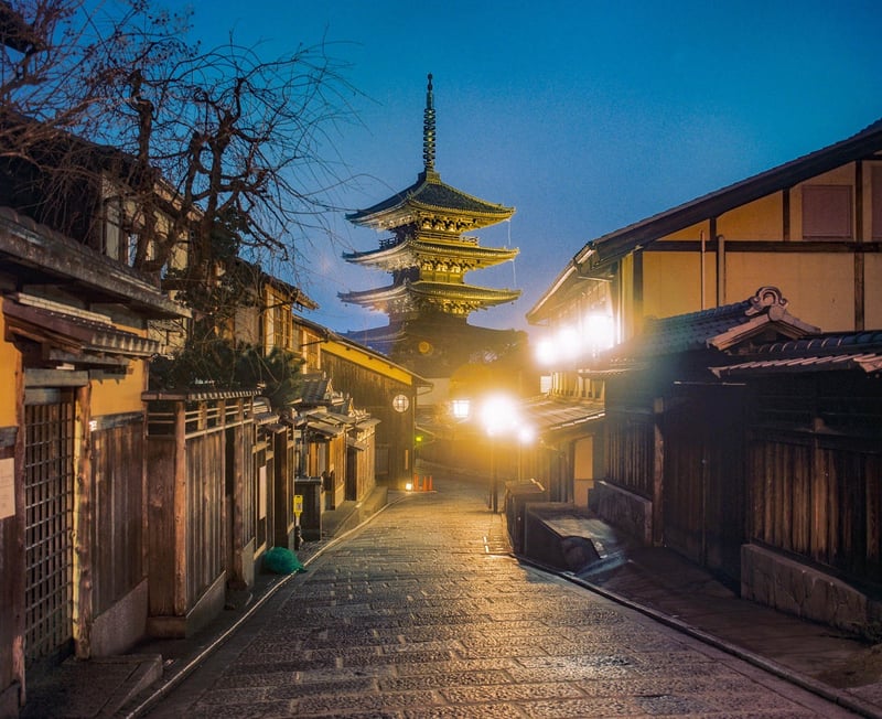 京都の夜、八坂の屋根が静かに月明かりに照らされる。